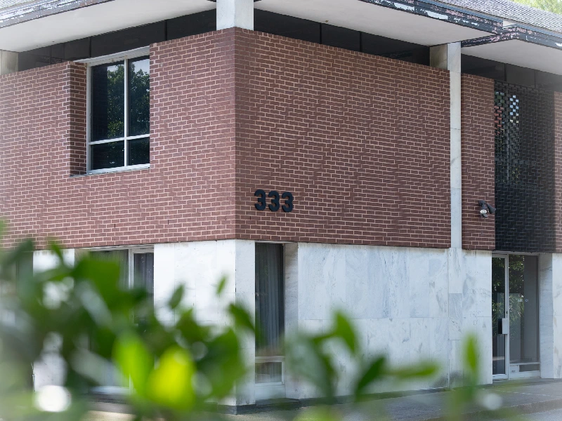 Modern building corner with brick and concrete walls and number 333.