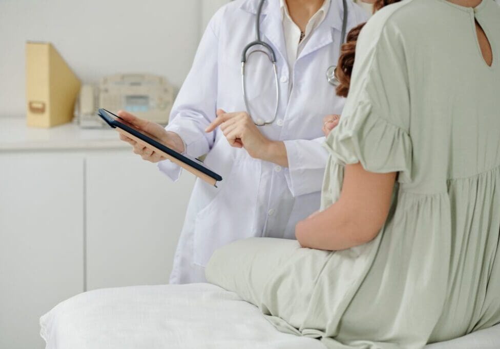Doctor showing patient tablet results.