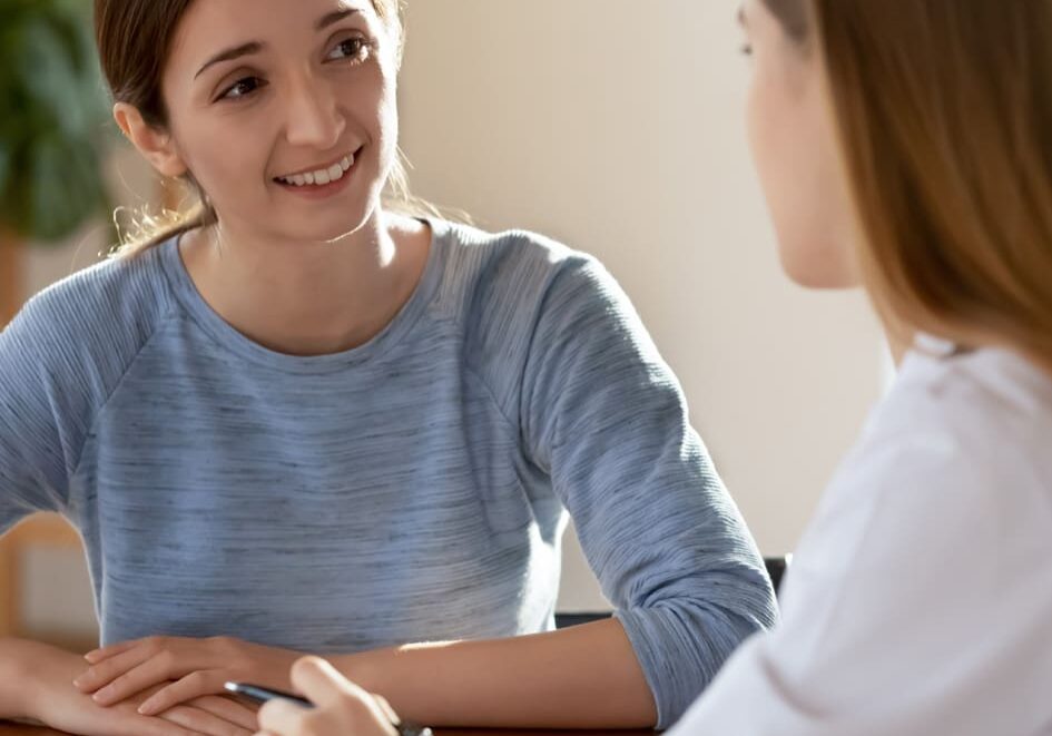 Two women engaged in a heartfelt conversation indoors.